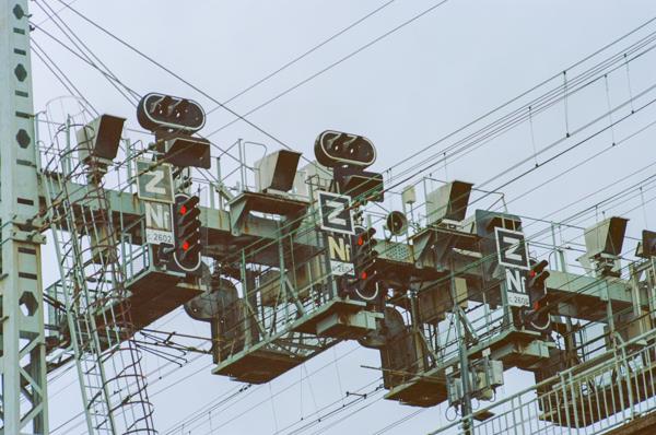 Un gros ensemble de signalisation ferroviaire, avec beaucoup de feux, des voyants rouges, et des tas de câble.